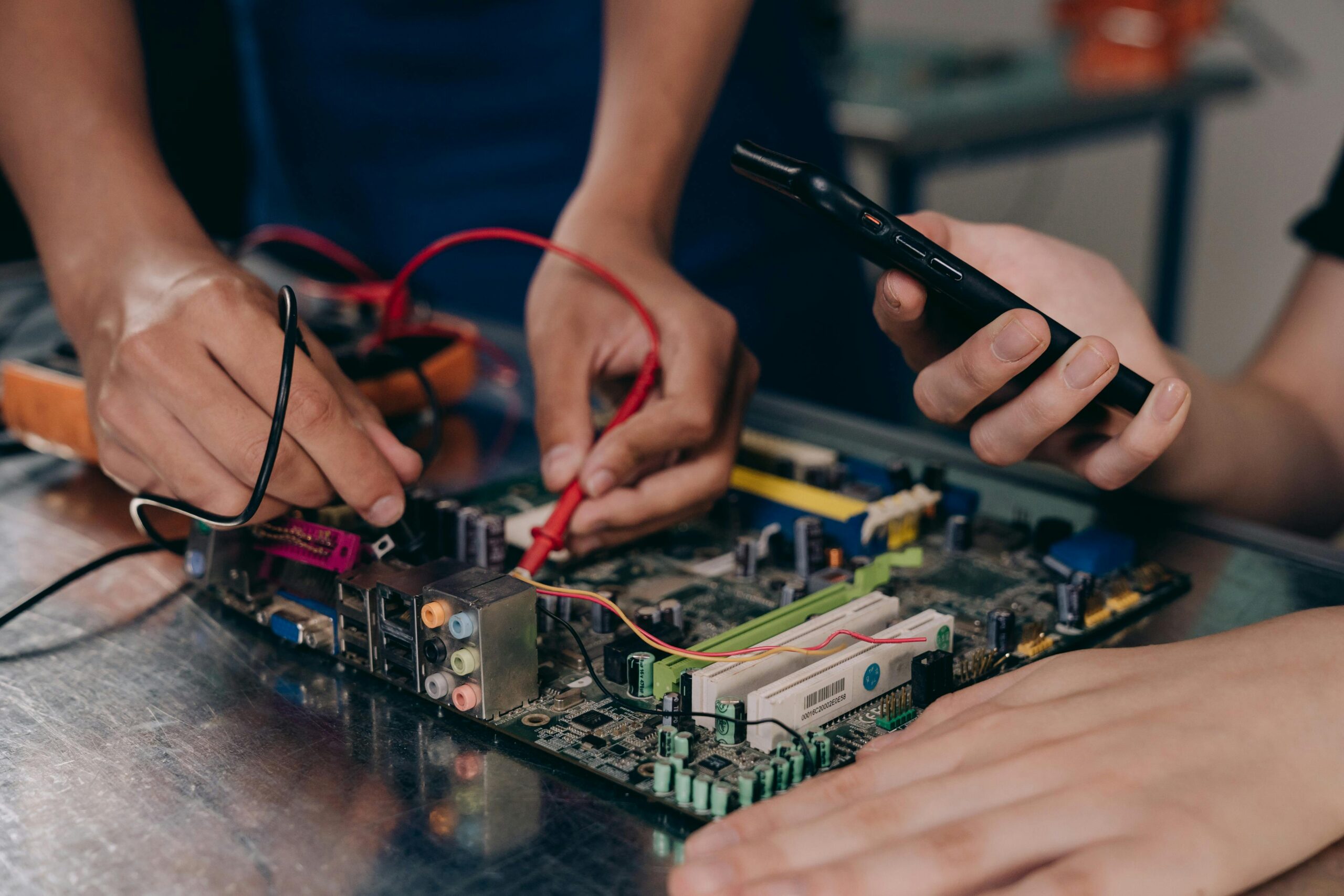 Electrical troubleshooting help with hands testing a circuit board using probes and tools